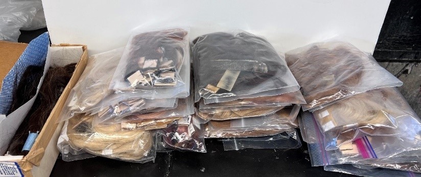 file of hair tresses of various colors in bags for donation